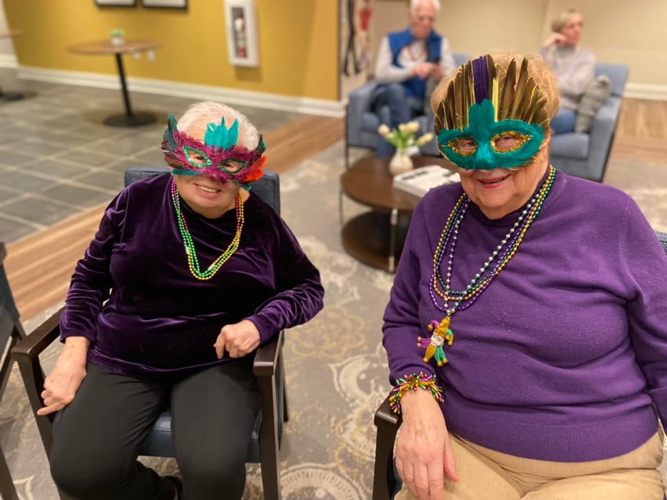 two female residents wearing mardi gras masks